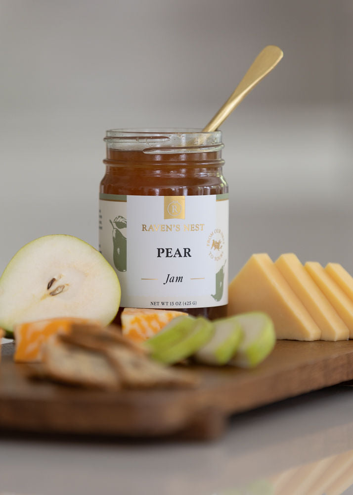 Pear Jam Jar sitting on a Cheese Board with a half pear, and cheese slices