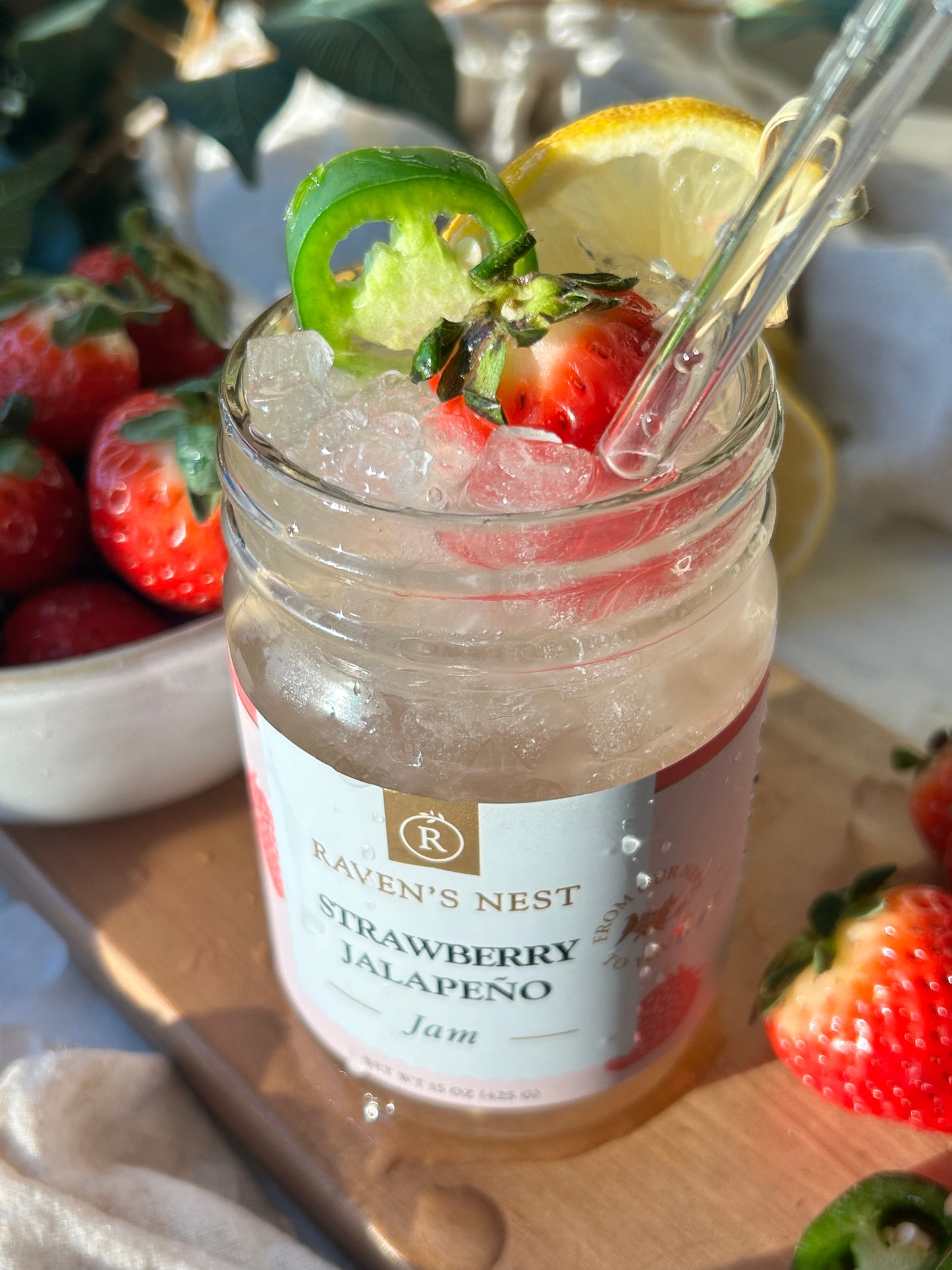 Non-alcoholic strawberry jalapeno mocktail recipe made from Drink Free Spirits zero proof gin and Raven's Nest strawberry jalapeno gourmet jam with bubbly water, garnished with fresh lemon, jalapeno slices, and berries