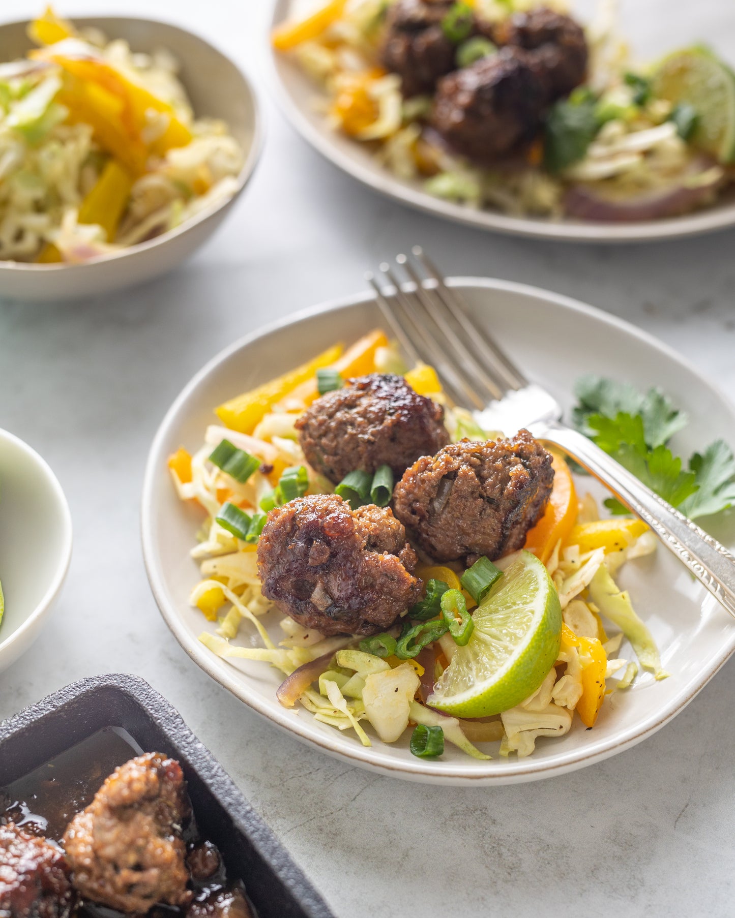 Asian Meatballs with Peach Habanero Jam Dressing Plated on a White Plate with a slaw garnish