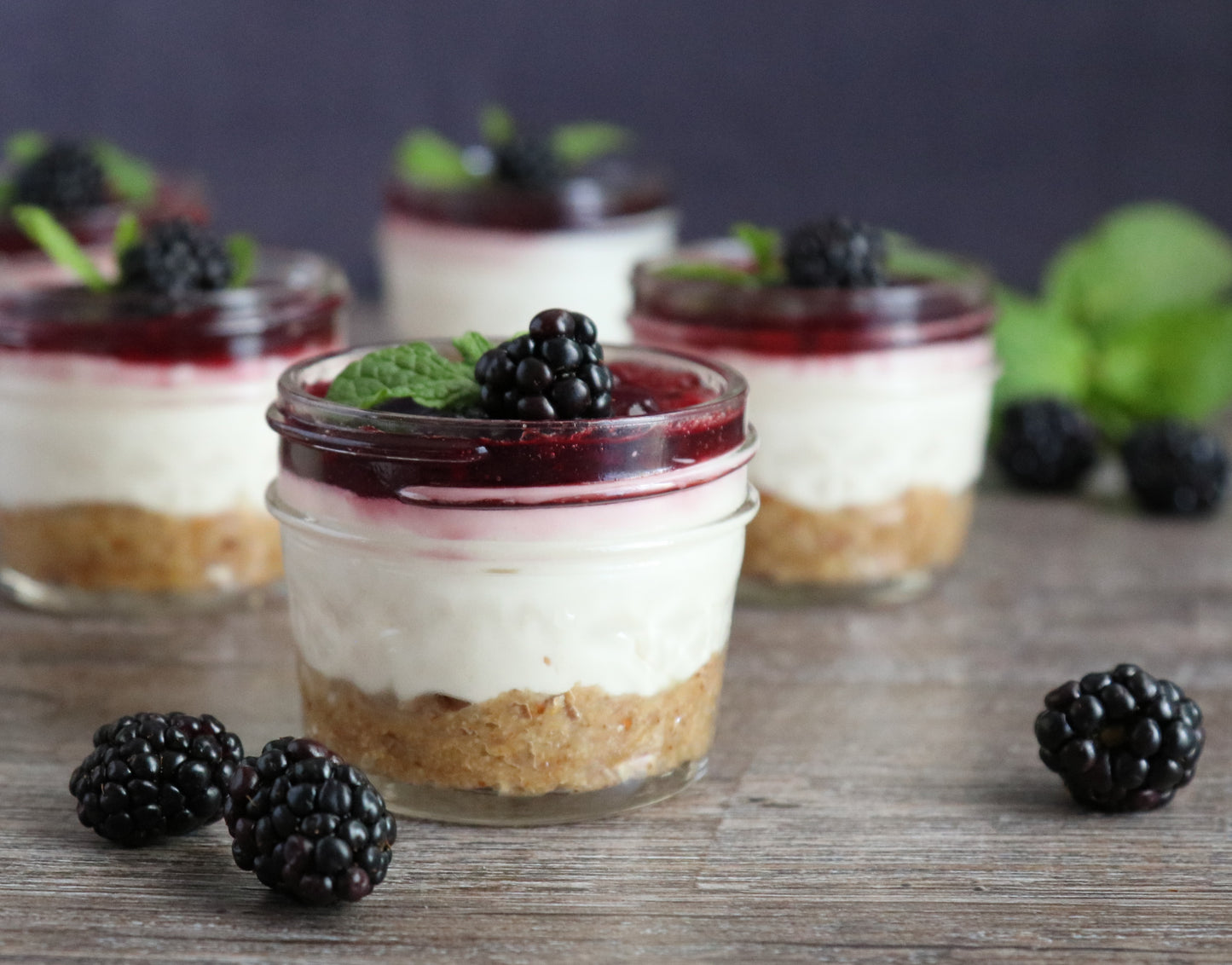 Goat Cheese Cheescake in mason jars topped with Blackberry Jalapeno Jam and Granished with fresh blackberrys