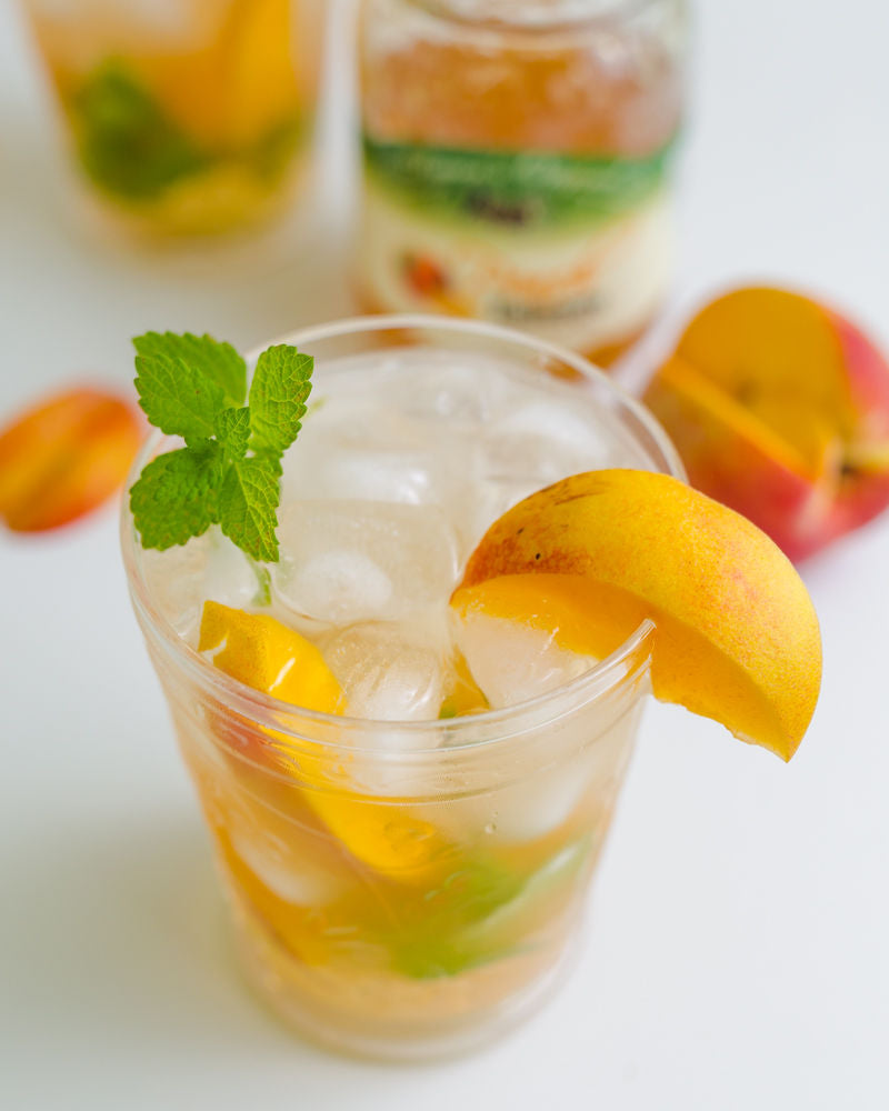 Peach Habanero Jam Mocktail made with a Peach Habanero Simple Syrup Garnished with a Sprig of Mint and a Peach Slice on Rim