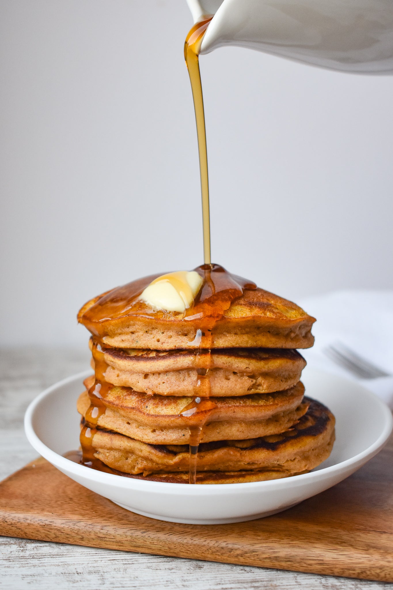 Pumpkin Butter Pancakes with a Pad of Butter on top and syrup poured on top