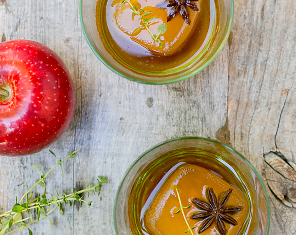 Spices bourbon cocktail made with Raven's Nest mulling spice garnished with herbs, anise stars and apple slices