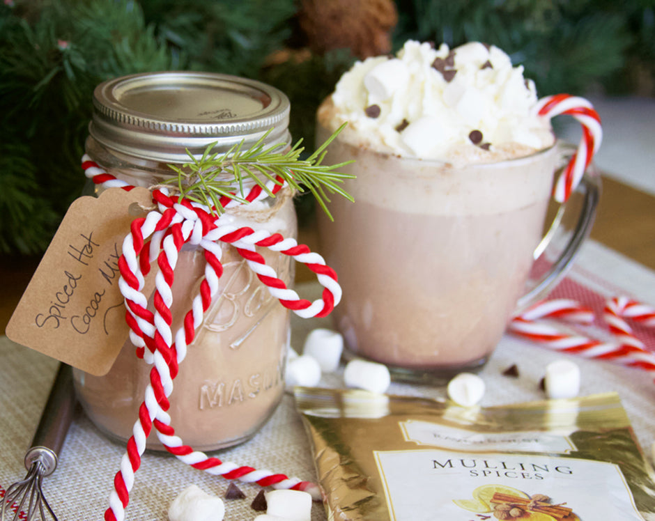 Spiced hot chocolate mix in a jar made with Raven's Nest mulling spices and a cup of hot cocoa topped with whipped cream