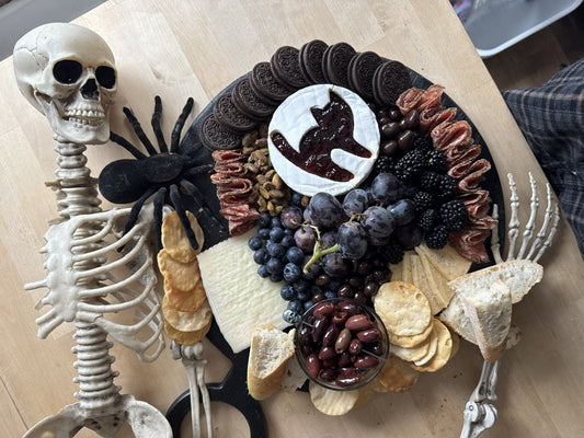 Create a Halloween Spook-cuterie Board with Raven’s Nest Blackberry Jalapeño Jam, cheeses, cured meats, fresh berries, chocolate treats, and spooky seasonal extras.