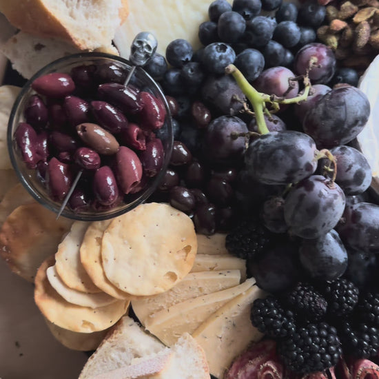 Create a Halloween Spook-cuterie Board with Raven’s Nest Blackberry Jalapeño Jam, cheeses, cured meats, fresh berries, chocolate treats, and spooky seasonal extras.