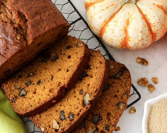 Pumpkin bread recipe with chopped walnuts made with Raven's Nest mulling spices surrounded by fall pumpkins