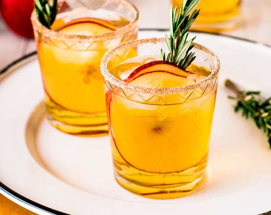 Spiced apple cider margarita cocktail recipe made with Raven's Nest mulling spice, garnished with cinnamon rim, apple slices, and fresh rosemary
