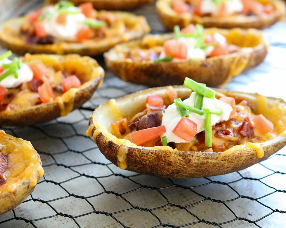 Potato skins filled with Raven's Nest chili grande and garnished with cheese, sour cream, tomatoes, and chives