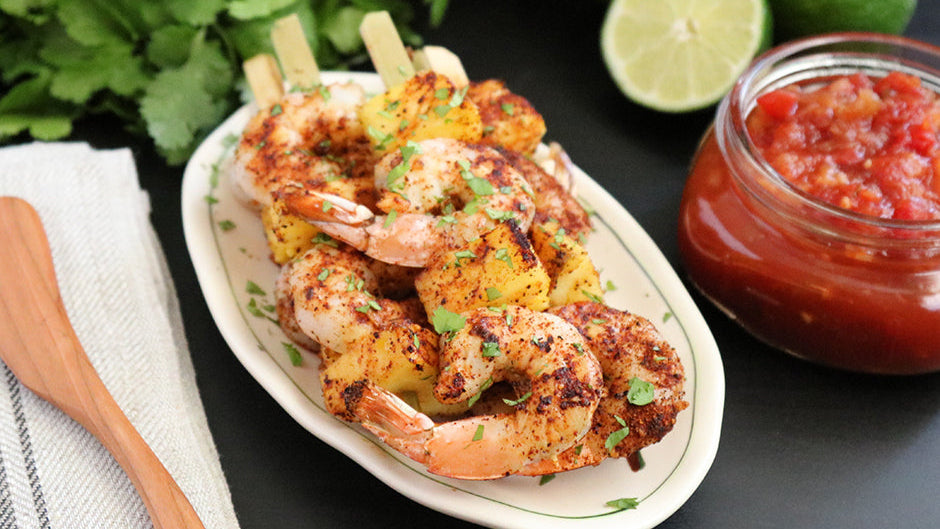 Raven's Nest chili grande rubbed shrimp on skewers with fresh pineapple served with a side of limes and pineapple salsa