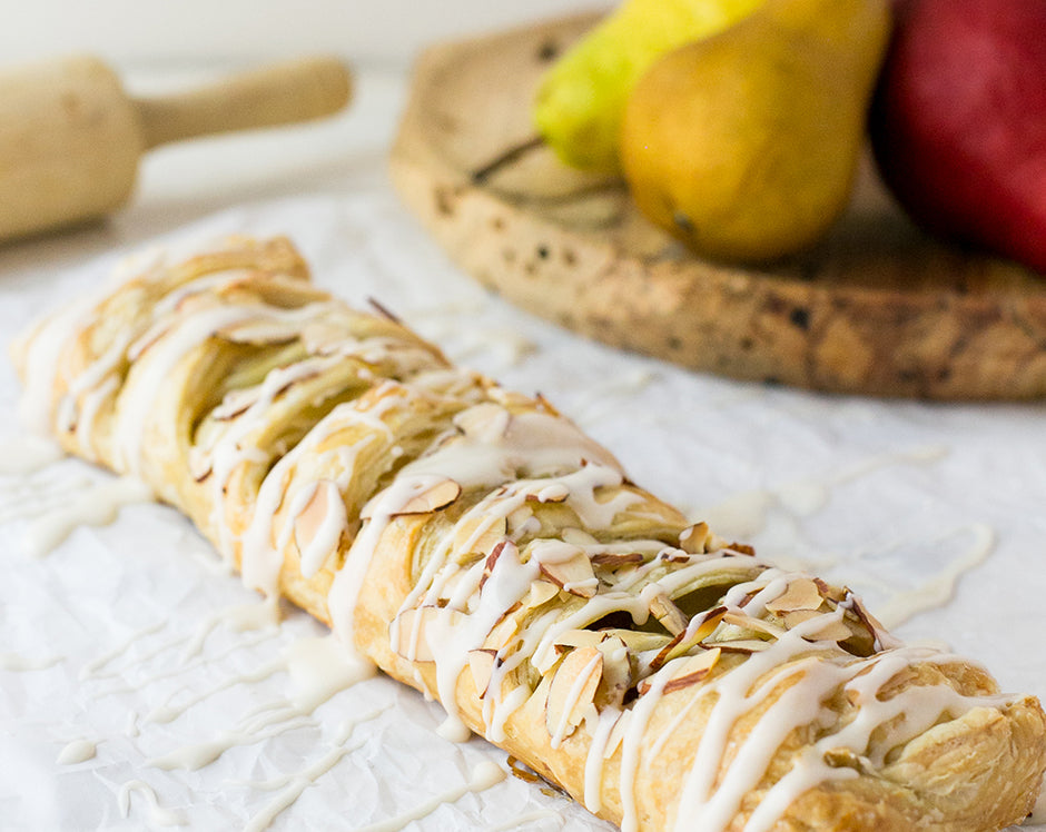 Cinnamon pear braid bread dessert made with Raven's Mulling Spice and Cinnamon pear jam and topped with glaze and sliced almonds