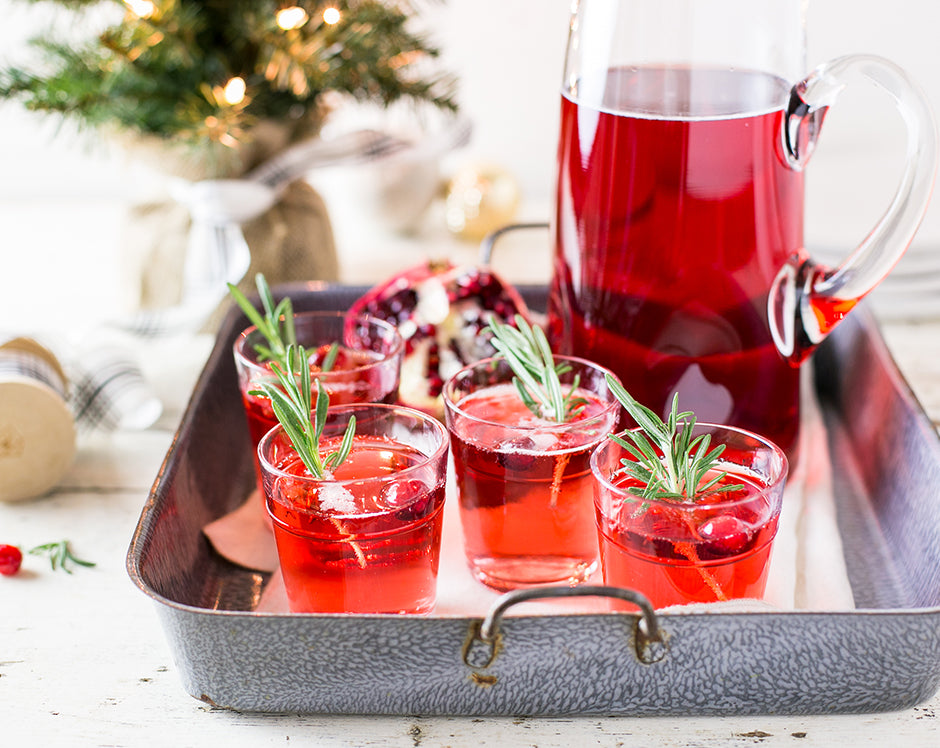 Cranberry pomegranate Christmas punch made with Raven's Nest mulling spices and garnished with rosemary