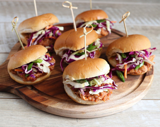 Pulled pork sliders made a bourbon peach habanero sauce made from Raven's Nest jam, topped with cole slaw and garnished with a party toothpick
